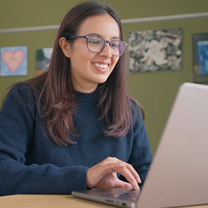 Alum Vanessa works on a laptop