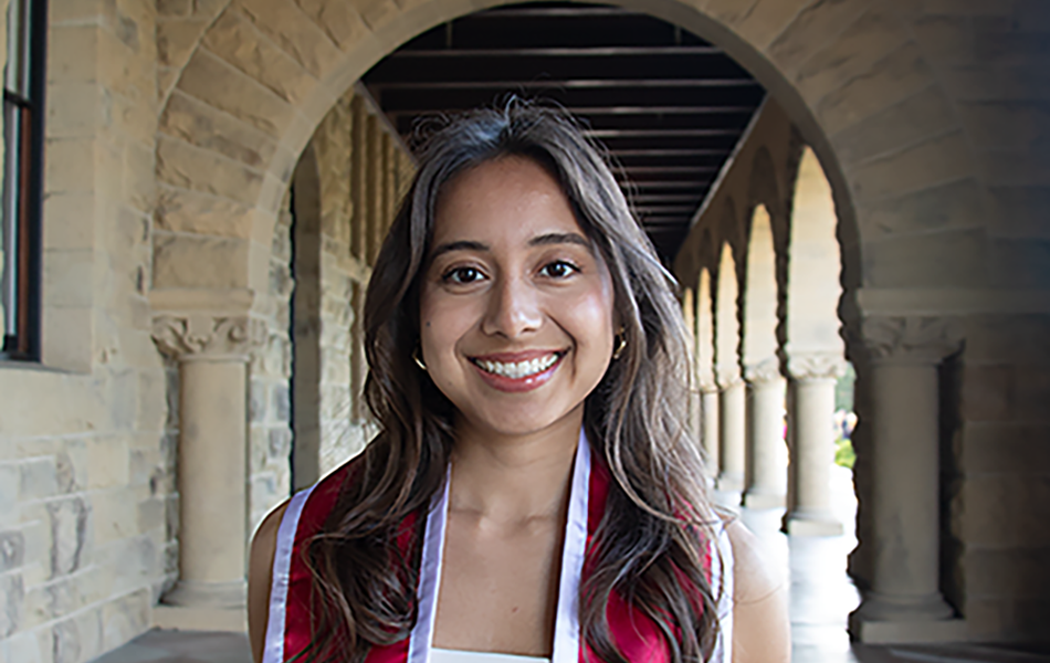 Senior in regalia under the Stanford Archway
